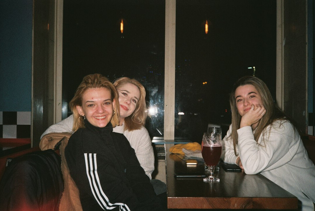 Group of friends talking and smiling around a table